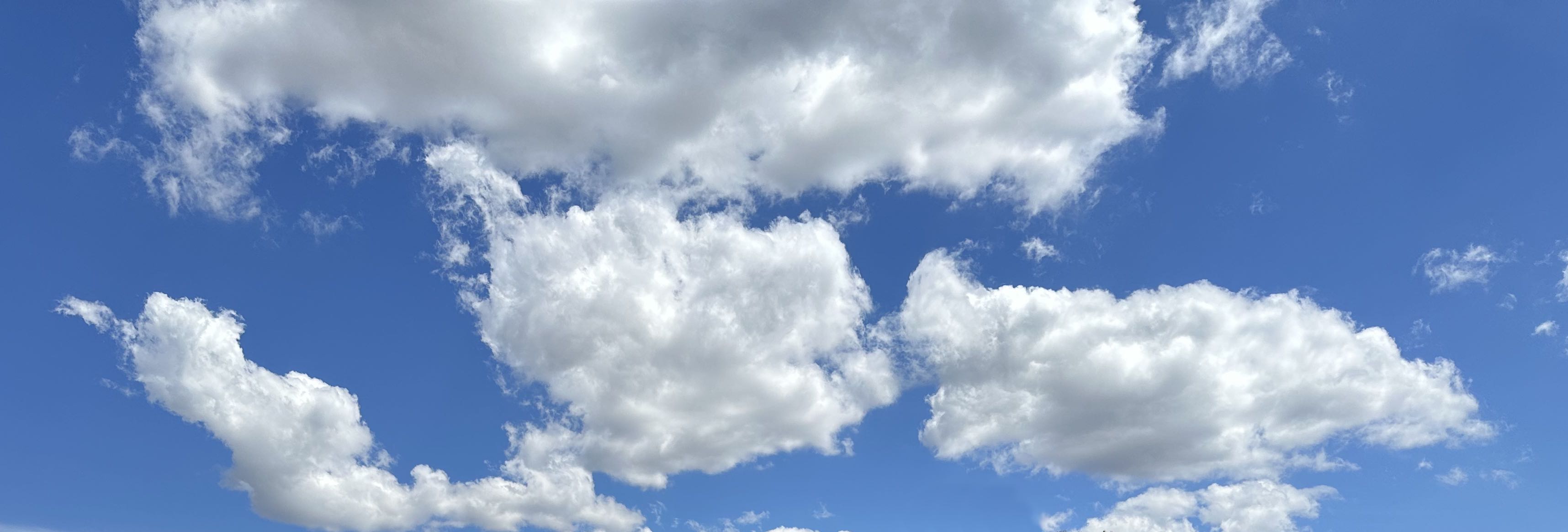 A blue sky with fluffy white clouds